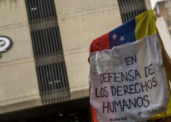 Manifestantes alzan una pancarta en defensa de los DDHH ante la sede del MP, una de las instancias de la justicia venezolana